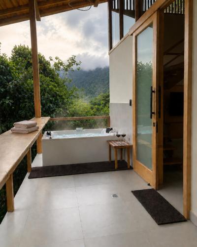 a bathroom with a tub and a view of the mountains at MindoLoft Loft de lujo con servicio premium en Mindo in Mindo