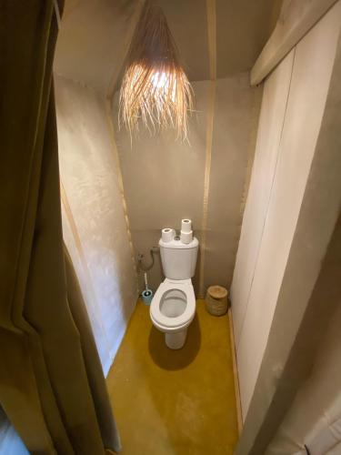 a bathroom with a toilet in a small room at Merzouga Luxury Camping in Merzouga