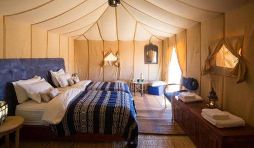 a bedroom with a large bed in a tent at Merzouga Luxury Camping in Merzouga