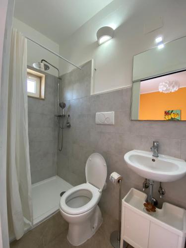 a bathroom with a toilet and a sink and a shower at Le Nuage in Torre Lapillo
