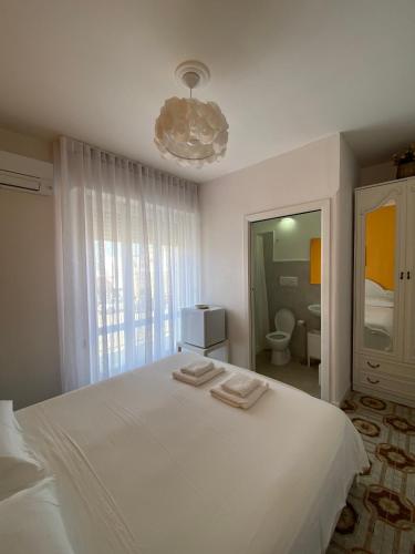 a bedroom with a white bed with two towels on it at Le Nuage in Torre Lapillo
