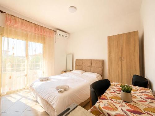 a bedroom with a bed and a table with chairs at Amarildo Rooms in Durrës