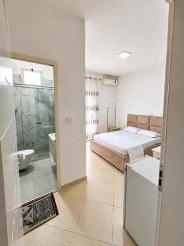 a bedroom with a bed and a bathroom with a tub at Amarildo Rooms in Durrës