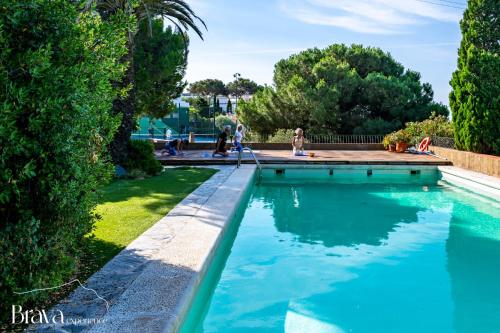 a pool in a yard with people playing in the water at Can Rino - Vistas panorámicas I piscina I tenis I terraza I Brava Experience in Cadaqués