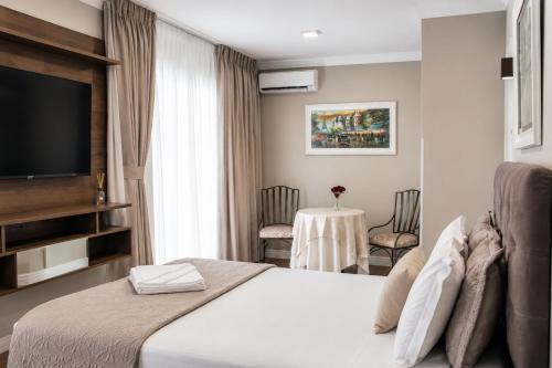 a hotel room with a bed and a table with chairs at Lagoa Parque Hotel in Lagoa Vermelha