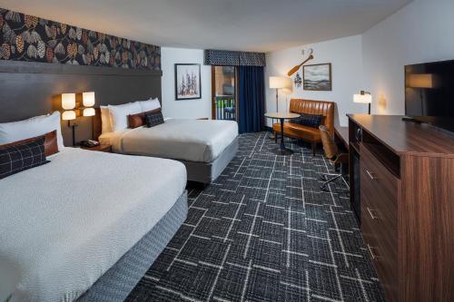 a hotel room with two beds and a desk at Pine Grove Resort in Ephraim