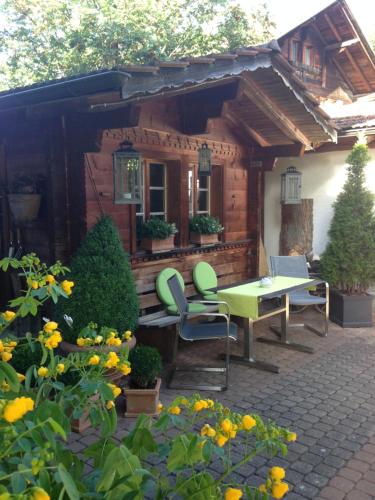 a wooden cabin with a table and chairs on a patio at Ferienwohnung Milchgaessli in Frutigen
