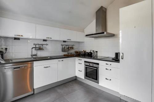 a kitchen with white cabinets and stainless steel appliances at 100 m terrace parking view of the Eiffel Tower in Saint-Cloud
