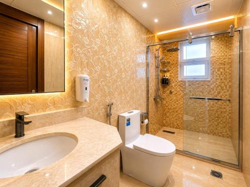 a bathroom with a toilet and a sink and a shower at Diamond Star Hotel فندق النجمة الماسية in Seeb
