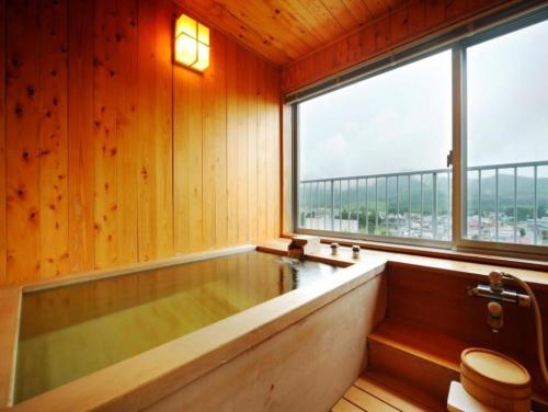 ein Badezimmer mit Badewanne und großem Fenster in der Unterkunft Oehonke in Kitami