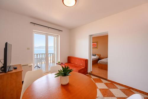 a living room with a table and a television at Royal Sea Panorama in Komarna