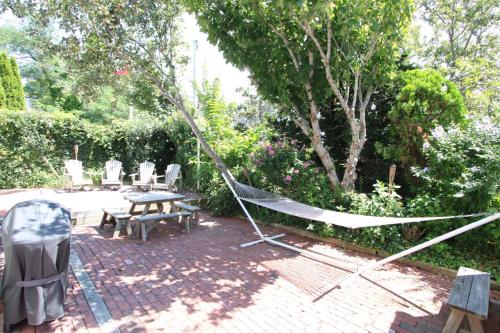 a hammock in a garden with a table and chairs at High Tide Lower Level in Provincetown