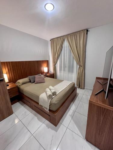 a bedroom with a large bed and a television at Habitaciones cómodas en Coto Galeana Guadalajara in Guadalajara