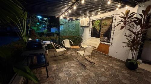 a patio with two chairs and a table with lights at Le”More House in Girardot