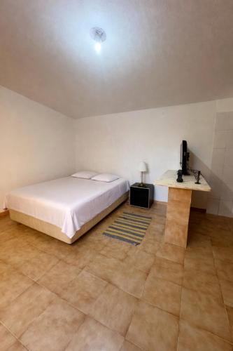 a bedroom with a bed and a television and a table at Vivenda Santos in Albufeira