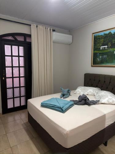 a bedroom with a bed with towels on it at Cantinho do Aconchego in São Lourenço