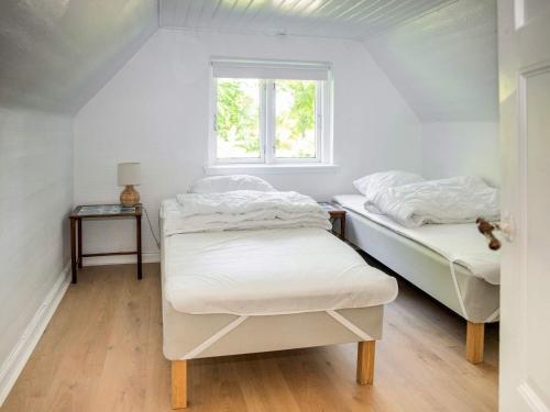 two beds in a room with a window at Historic Gem in Samsø in Brundby