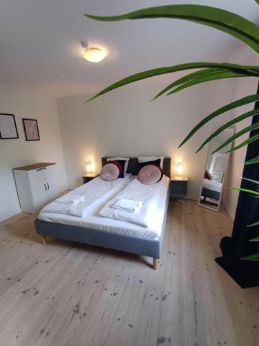a bedroom with a bed with two pillows and a plant at Charming 2 bedroom apartment free parking in Hjørring