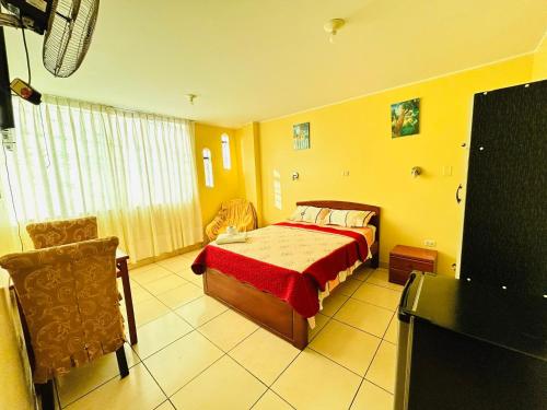 a bedroom with a bed with a red blanket at Sandel Barranca Peru in Barranca