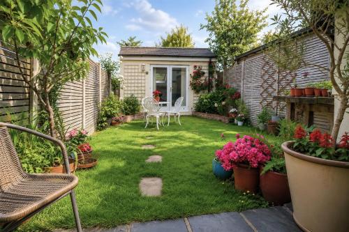 a small garden with a table and chairs and flowers at Garden room, central Winchester in Winchester