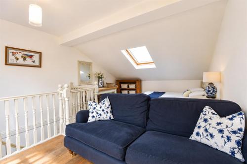 a living room with a blue couch and a bed at Garden room, central Winchester in Winchester