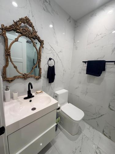 a bathroom with a sink and a toilet and a mirror at The Hudson Horizon in West New York