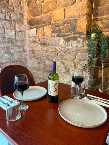 a table with two glasses and a bottle of wine at The Old Manor House Hotel in Keynsham