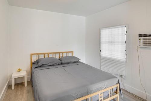 a white bedroom with a bed and a window at 4 Mi to Surfside Beach! North Miami Apt in North Miami