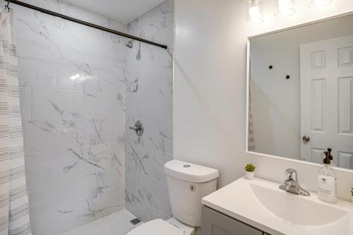 a white bathroom with a toilet and a sink at 4 Mi to Surfside Beach! North Miami Apt in North Miami