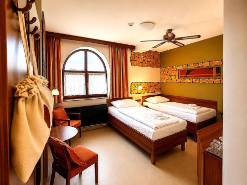 a hotel room with two beds and a window at Hotel Vinopa in Hustopeče