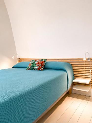a bedroom with a blue bed with a pillow on it at Sanremo Apartments - Marilux in Sanremo