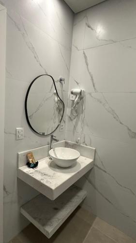 a bathroom with a sink and a mirror on a counter at Pousada raios de sol in Chapada dos Guimarães