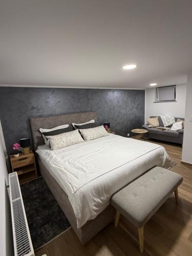 a bedroom with a large white bed and a couch at Villa Verdea Lopatinec in Lopatinec