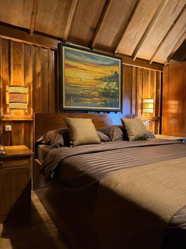 a large bed in a room with wooden walls at Dopi Rinjani Homestay in Tetebatu