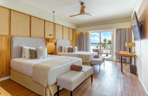 a hotel room with two beds and a balcony at Santo Domingo Bay Convention Resort & Casino in Boca Chica