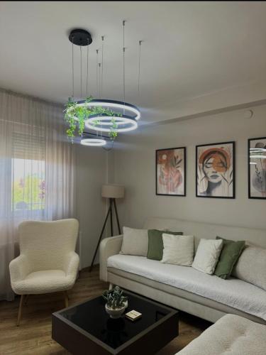 a living room with a couch and a chandelier at Apartman Una in Leskovac