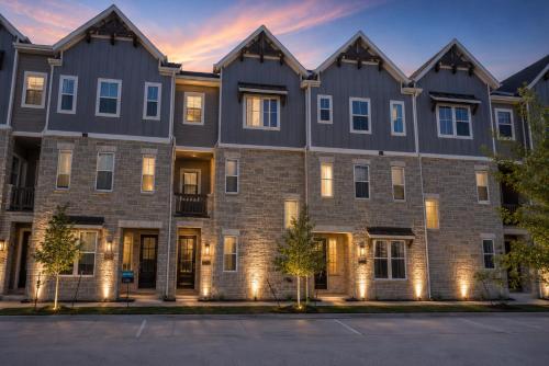 an apartment building at dusk with lights on at Collin Creek Executive Residences in Plano