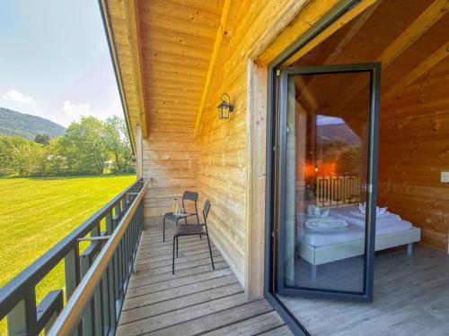 a porch of a log cabin with a bed and chairs at Rattendorf 13A in Rattendorf