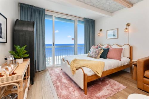 a bedroom with a bed with a view of the ocean at Penthouse Oceanfront Studio VR + Mural + Minibar in Myrtle Beach