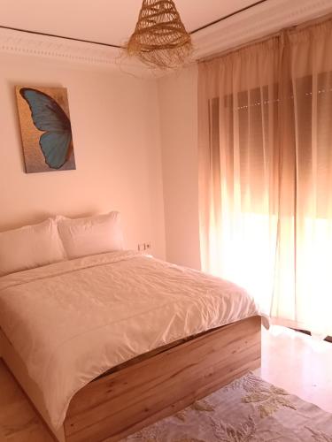 a bedroom with a large bed and a window at L'hivernage andalouse 4 in Marrakesh