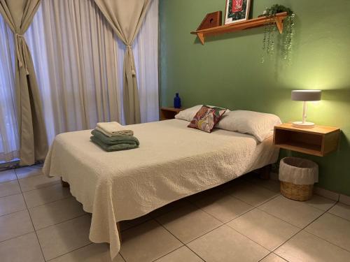 a bed in a room with a green wall at Casa Matia in Guadalajara