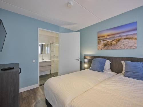 a bedroom with a large bed with blue walls at Sea Quality 83 in Colijnsplaat