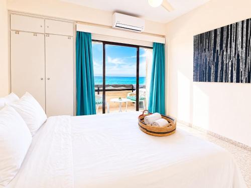 a bedroom with a bed with a view of the ocean at The Seafront Pearl in Larnaca
