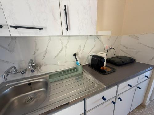 a kitchen counter with a sink and a microwave at The Seafront Pearl in Larnaca