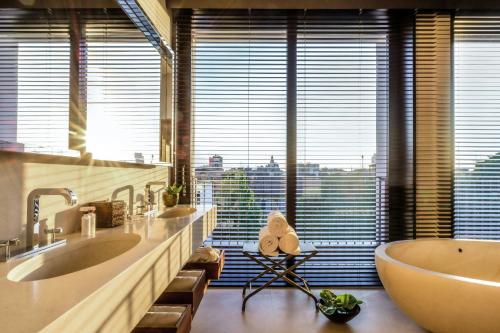 a bathroom with two sinks and a large window at Bvlgari Hotel Milano in Milan