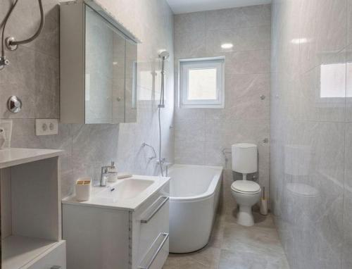 a white bathroom with a toilet and a sink at Apartments and rooms by the sea Podaca, Makarska - 16160 in Podaca