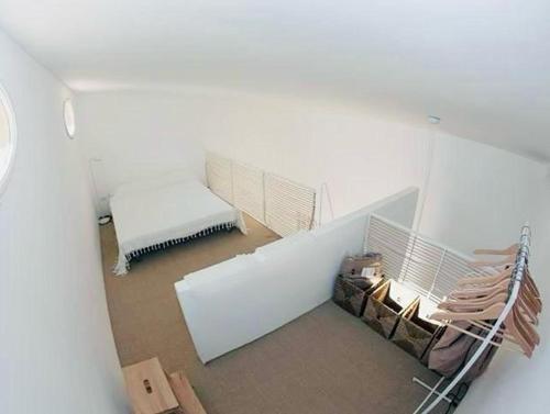 a white room with a bench and a bed at Casottino presso residenza Rosso di Sera in Capoliveri