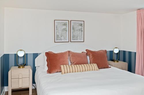 a bedroom with a white bed with two lamps at Penthouse 1BR + Bunk Room Boardwalk View Zone in Myrtle Beach