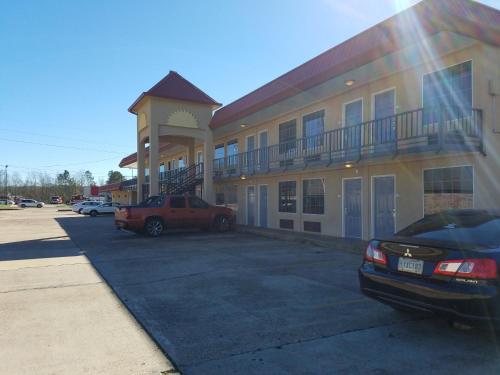 a large building with cars parked in a parking lot at Days Inn by Wyndham Leesville in Leesville