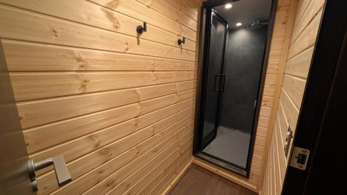 a wood paneled wall with a shower in a tiny house at The Joint in Hakuba